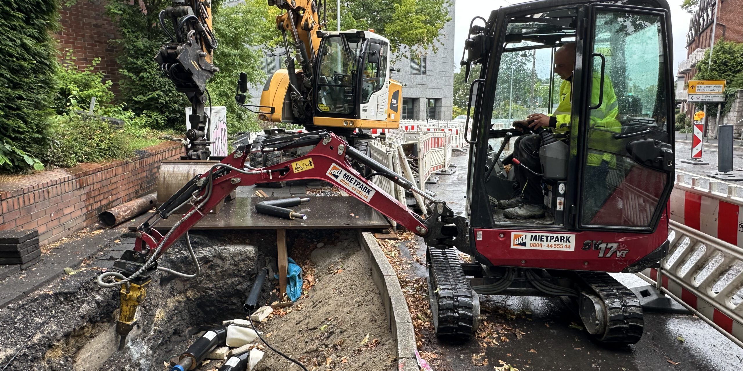 Zwei Bagger arbeiten an einer Baugrube.