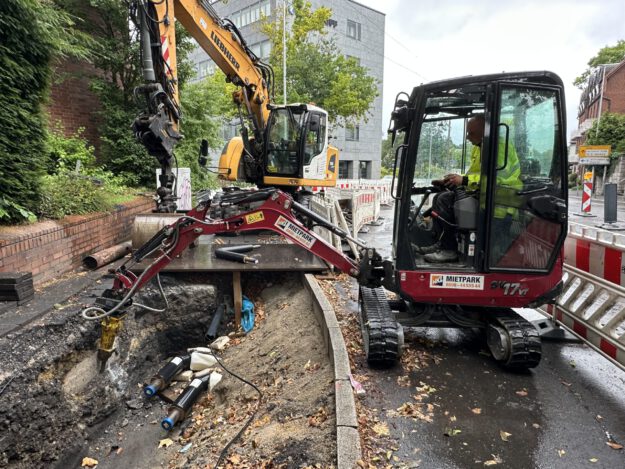 Zwei Bagger arbeiten an einer Baugrube.