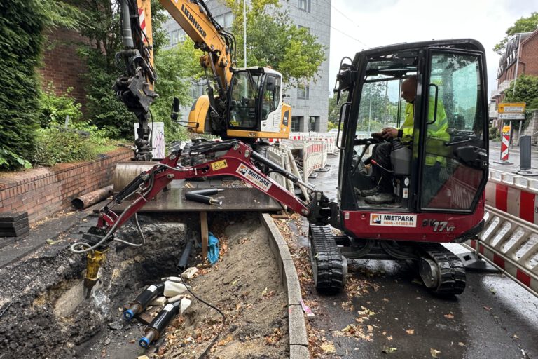 Zwei Bagger arbeiten an einer Baugrube.