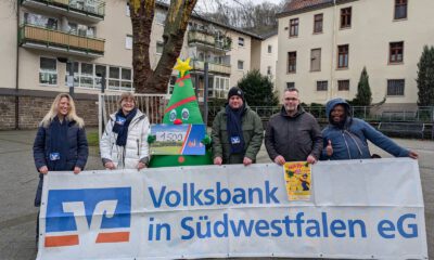 Menschen halten ein Werbebanner.