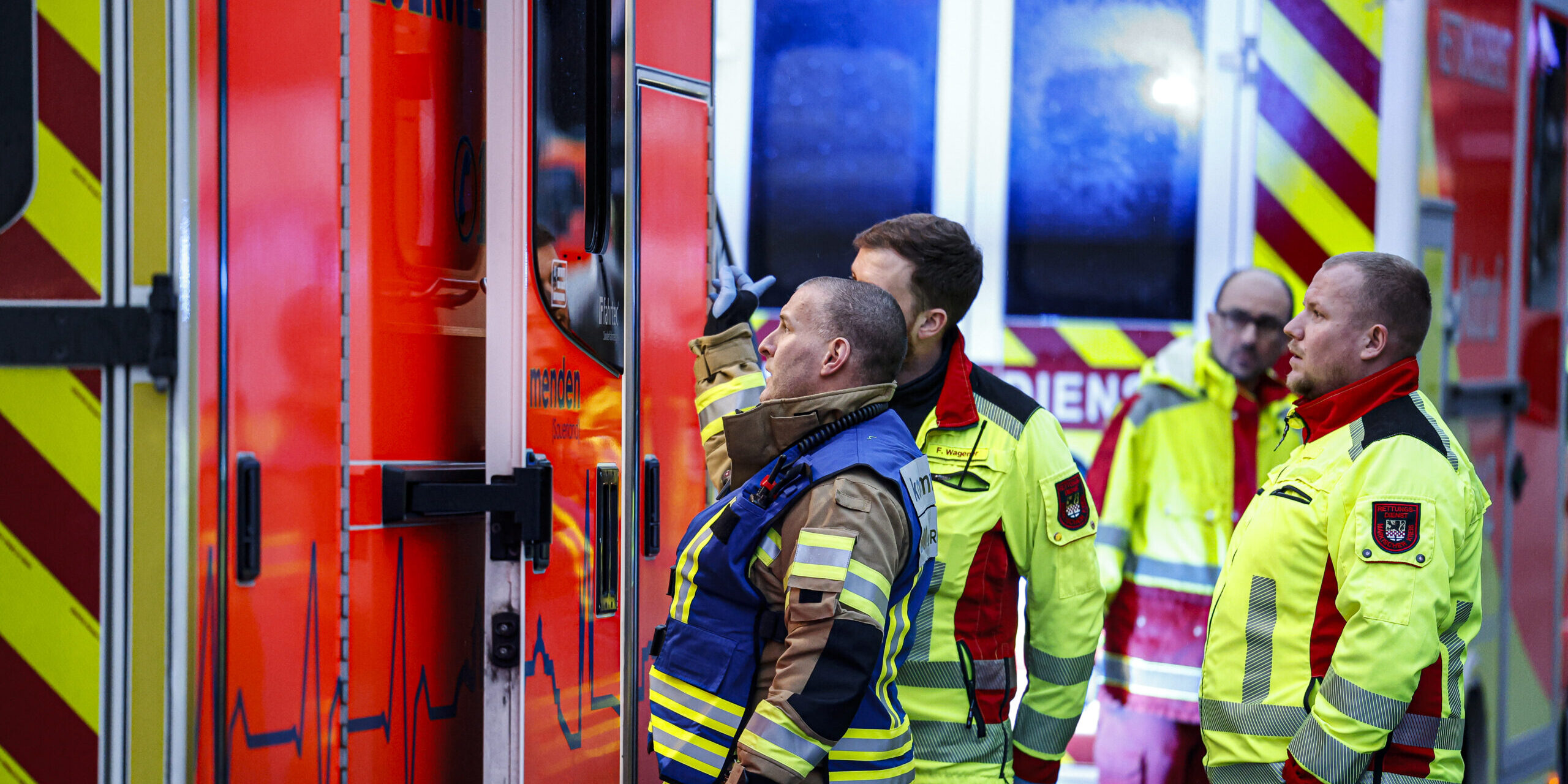 Einsatzkräfte stehen vor einem Rettungswagen