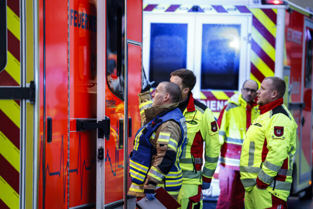 Einsatzkräfte stehen vor einem Rettungswagen