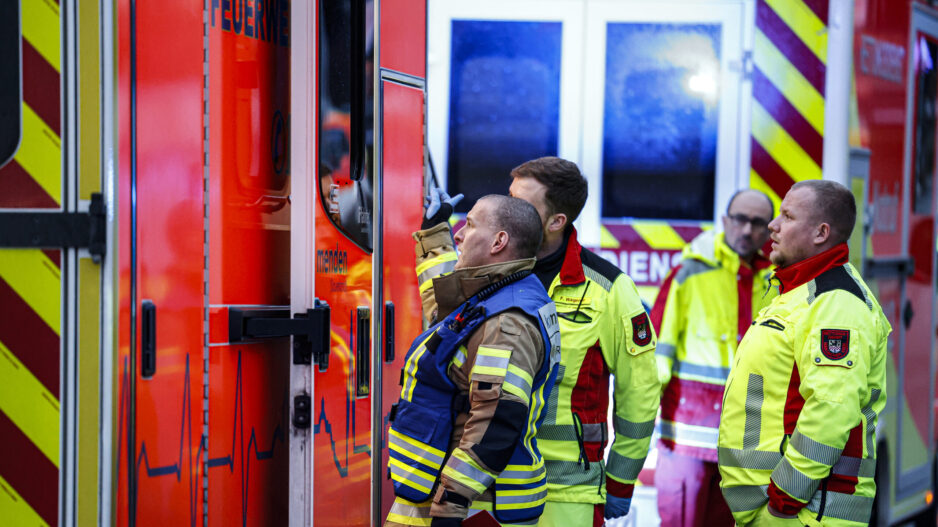 Einsatzkräfte stehen vor einem Rettungswagen