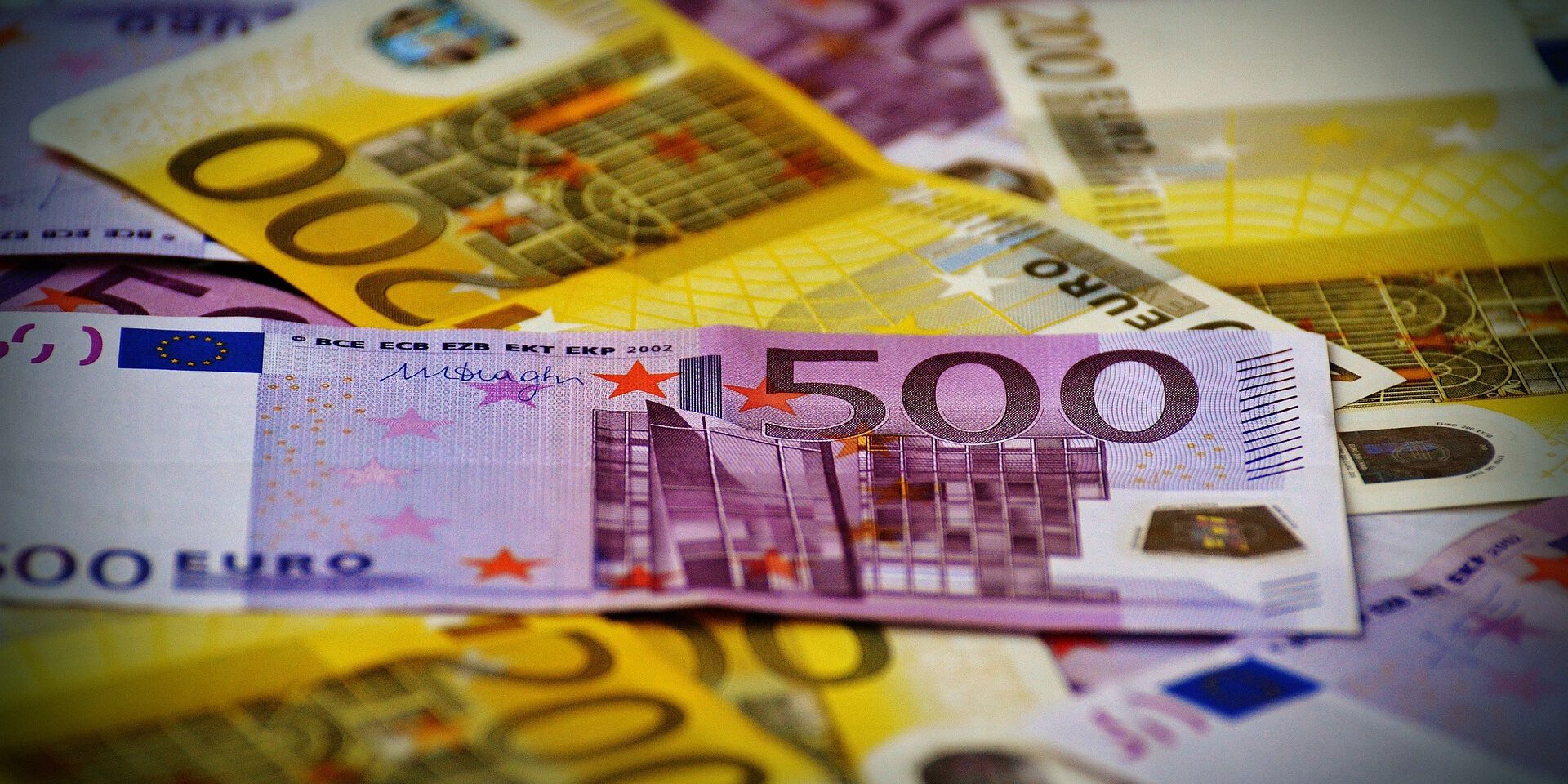 Mehrere Euro-Banknoten unterschiedlicher Stückelungen liegen übereinander, im Vordergrund ist ein 500-Euro-Schein deutlich zu sehen.