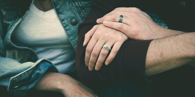 Zwei Menschen halten sich an den Händen.