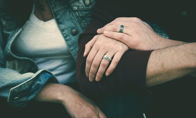 Zwei Menschen halten sich an den Händen.