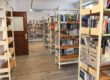 Mehrere Bücherregale mit Sachbüchern und Romanen stehen in einem hellen Raum einer Bibliothek.