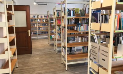 Mehrere Bücherregale mit Sachbüchern und Romanen stehen in einem hellen Raum einer Bibliothek.