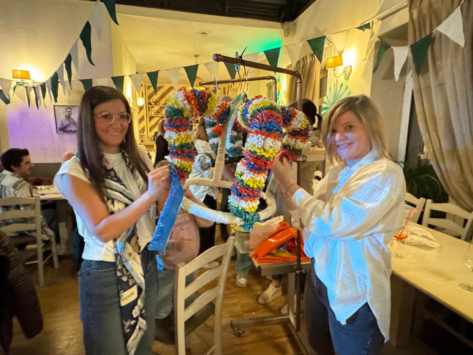 Zwei Frauen binden eine Krone.