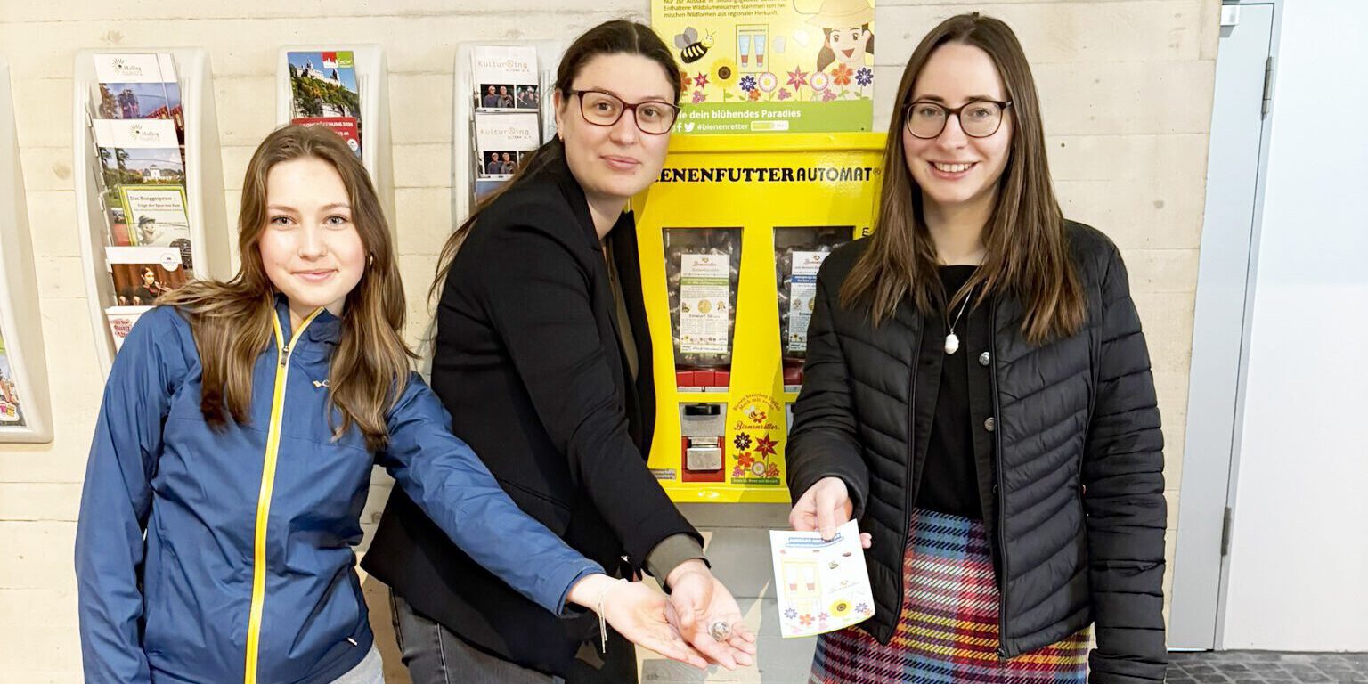 Drei Frauen vor einem Saatgutautomaten