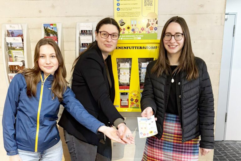 Drei Frauen vor einem Saatgutautomaten