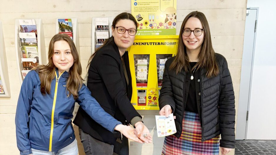 Drei Frauen vor einem Saatgutautomaten