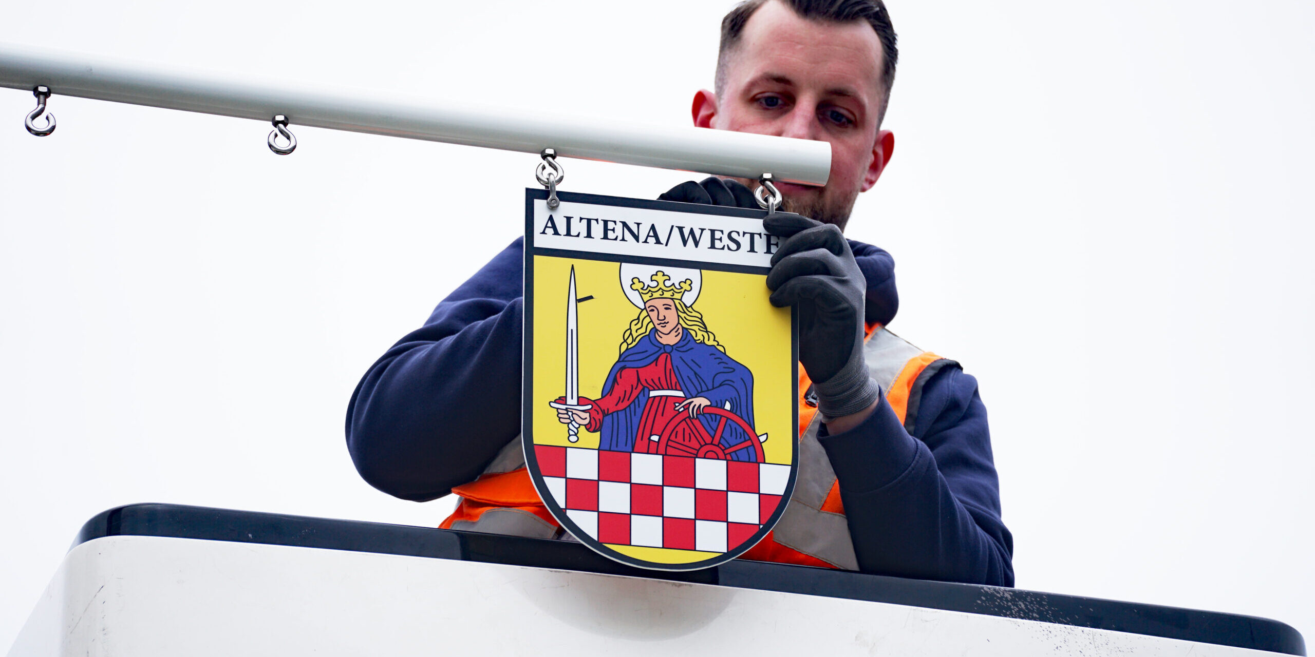 Jan Marzecki bringt das Abzeichen der Stadt am Maibauman