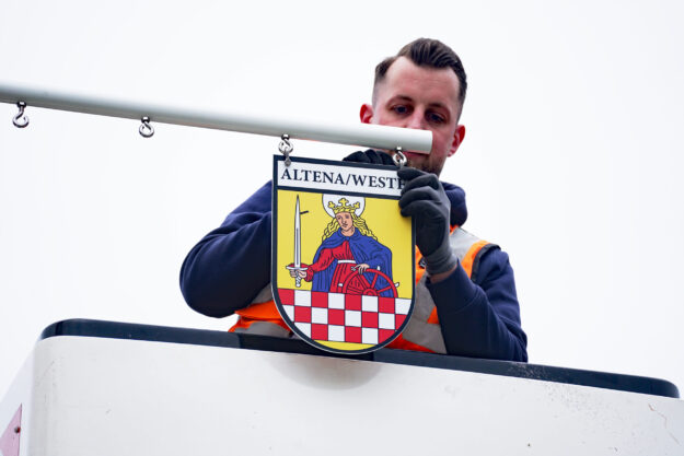 Jan Marzecki bringt das Abzeichen der Stadt am Maibauman