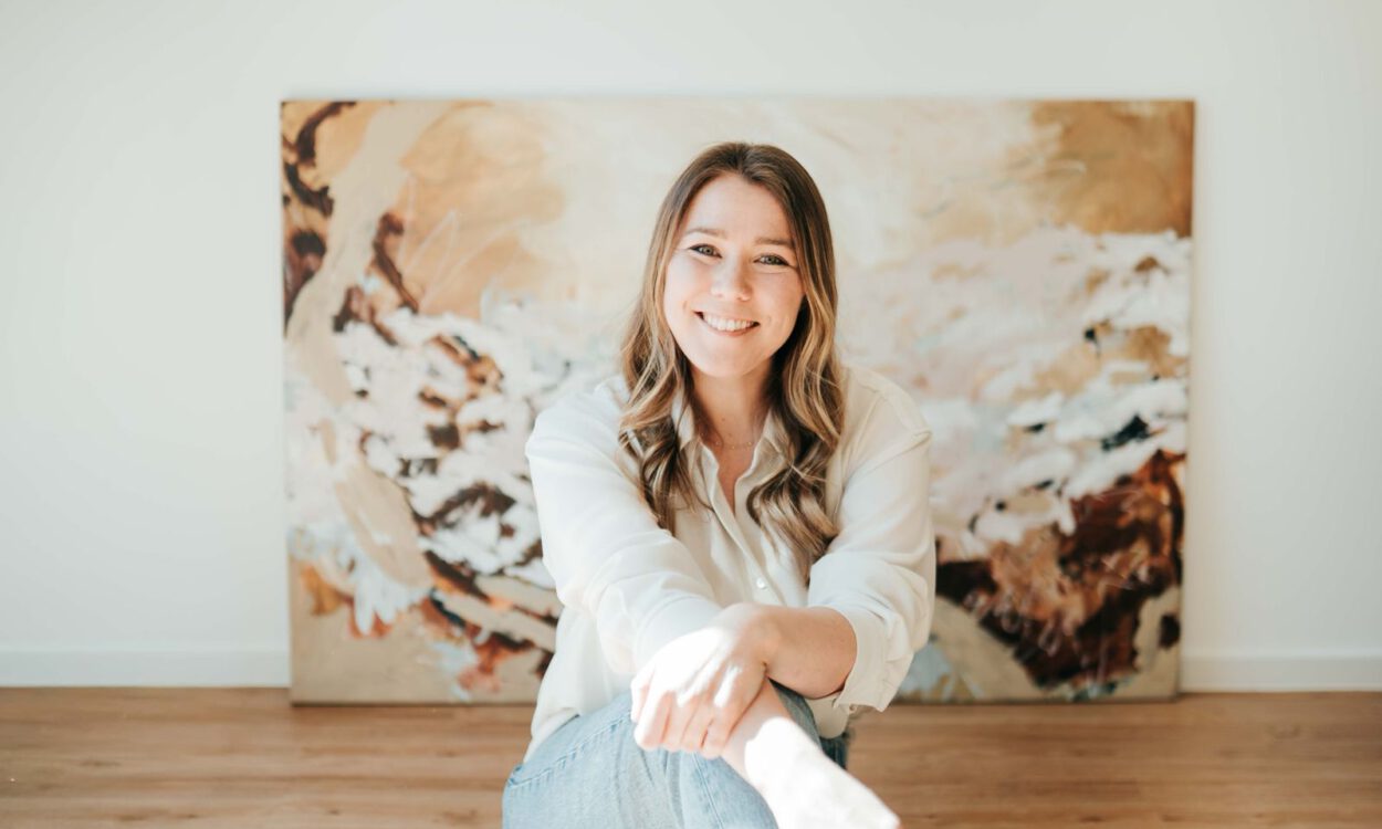 Eine junge Frau vor ihrem Gemälde.