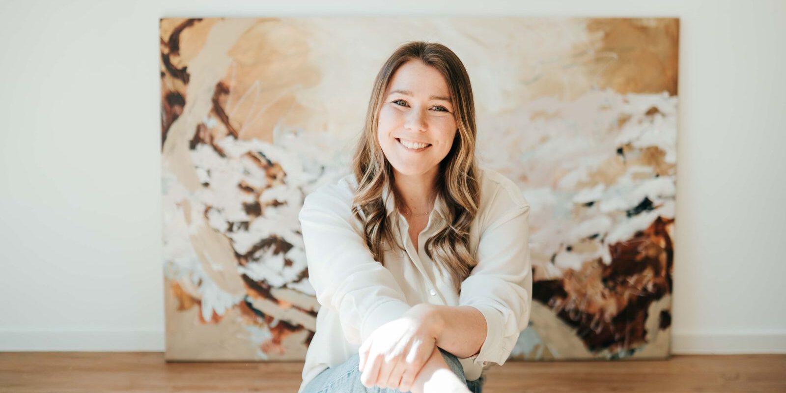 Eine junge Frau vor ihrem Gemälde.