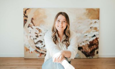 Eine junge Frau vor ihrem Gemälde.