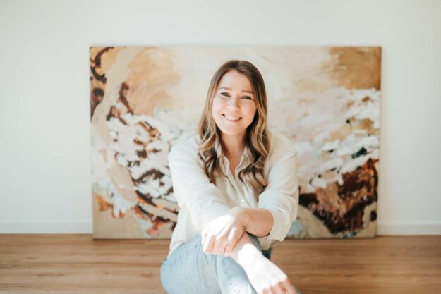 Eine junge Frau vor ihrem Gemälde.