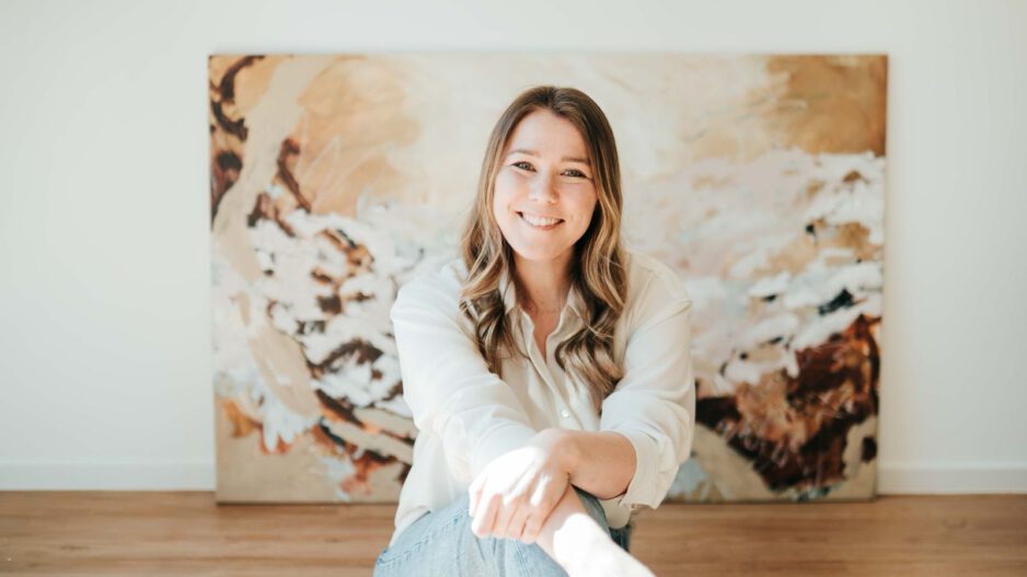 Eine junge Frau vor ihrem Gemälde.