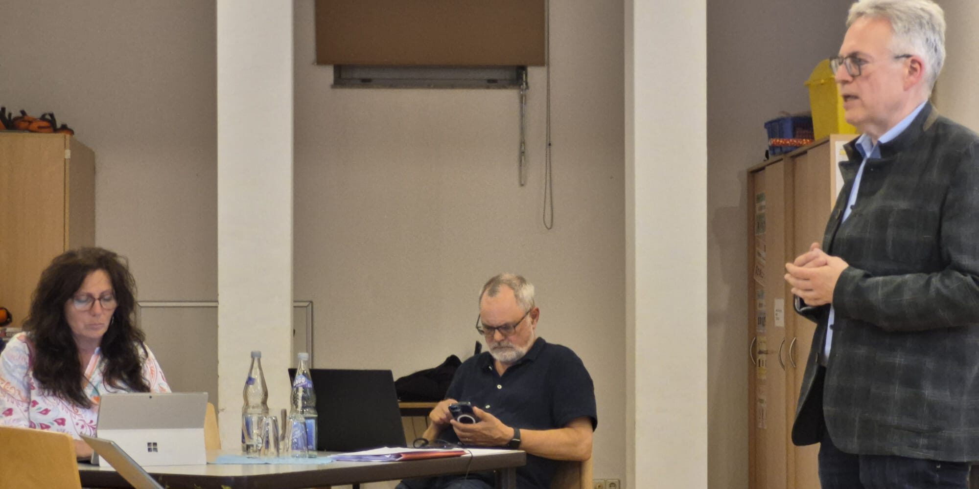 Drei Presbyter bei einer Versammlung.