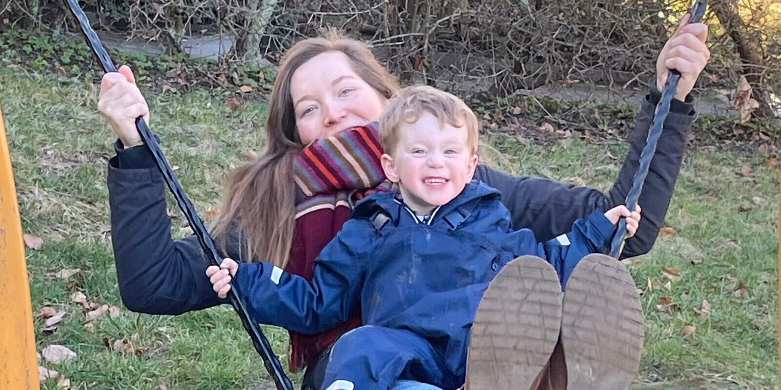 Eine Tagesmutter mit einem Kind auf der Schaukel