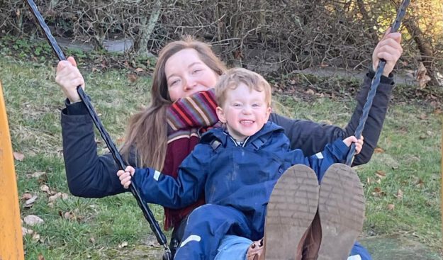 Eine Tagesmutter mit einem Kind auf der Schaukel