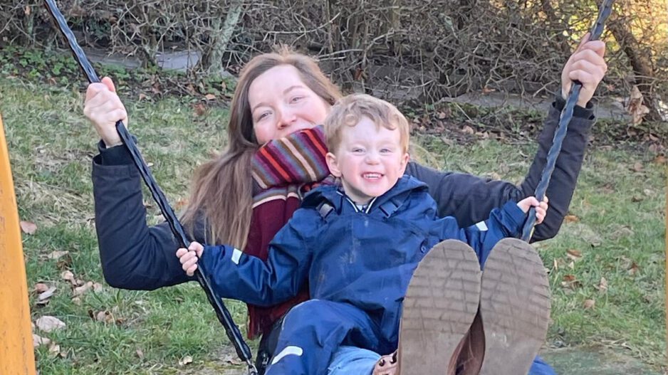 Eine Tagesmutter mit einem Kind auf der Schaukel