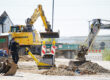 Eine Baustelle mit einem Bagger und Warnbaken.