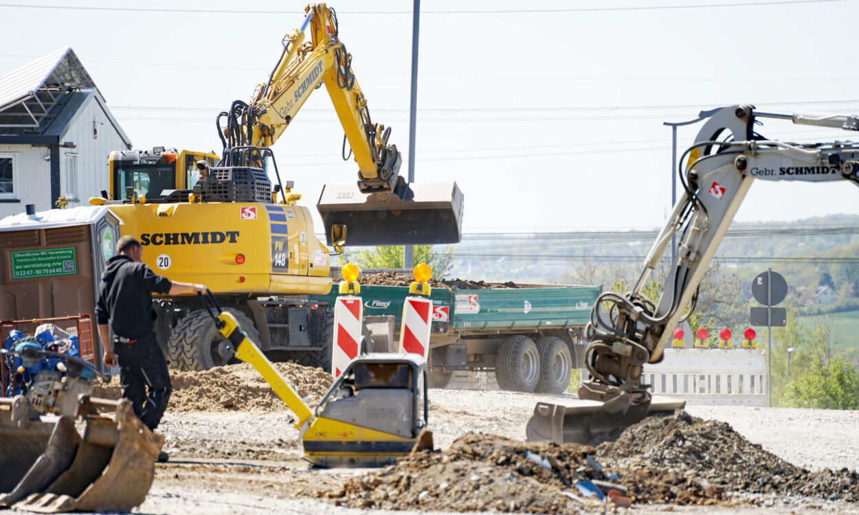 Eine Baustelle mit einem Bagger und Warnbaken.