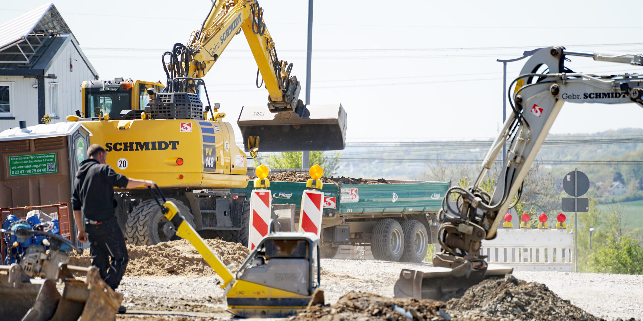 Eine Baustelle mit einem Bagger und Warnbaken.