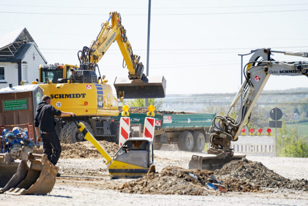 Eine Baustelle mit einem Bagger und Warnbaken.