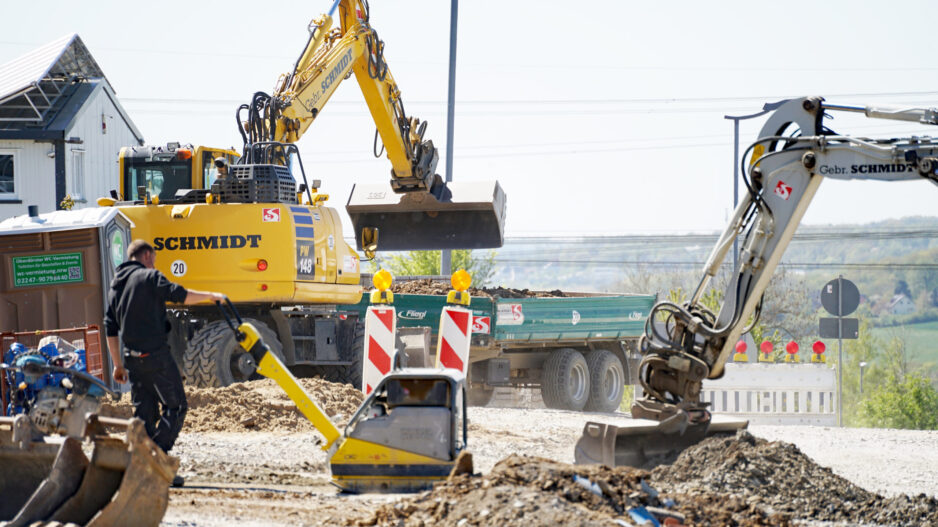 Eine Baustelle mit einem Bagger und Warnbaken.