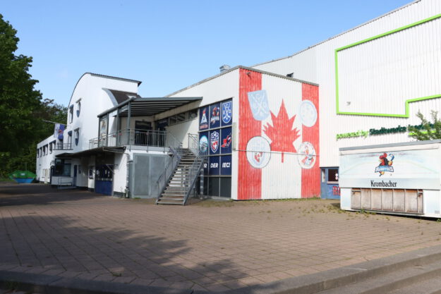 Foto: Oliver Bergmann Außenansicht einer Eissporthalle mit Logos der Iserlohn Roosters und großem Ahornblatt an der Fassade.