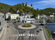 Blick auf den Kreisverkehr am Markaner, rechts fließt die Lenne und im Hintergrund sieht man die Burg Altena auf einem bewaldeten Hügel.
