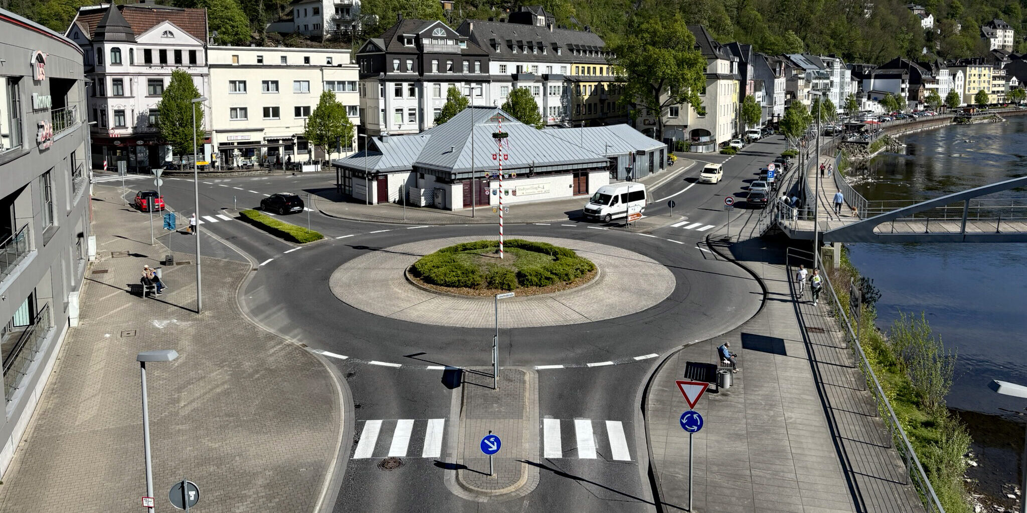 Blick auf den Kreisverkehr am Markaner, rechts fließt die Lenne und im Hintergrund sieht man die Burg Altena auf einem bewaldeten Hügel.