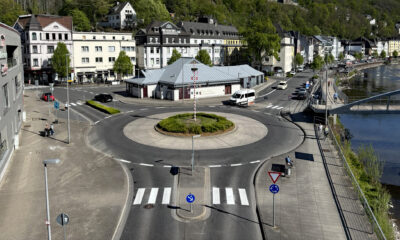 Blick auf den Kreisverkehr am Markaner, rechts fließt die Lenne und im Hintergrund sieht man die Burg Altena auf einem bewaldeten Hügel.