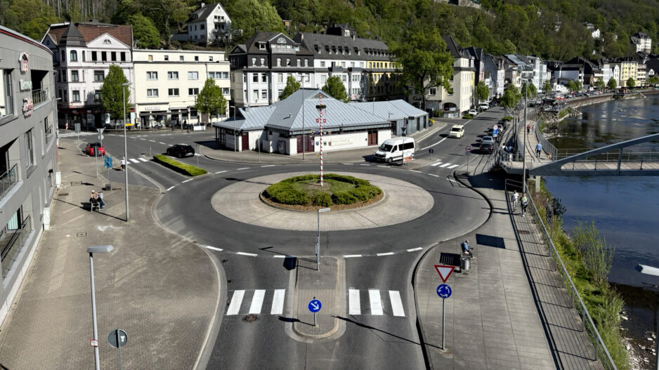Blick auf den Kreisverkehr am Markaner, rechts fließt die Lenne und im Hintergrund sieht man die Burg Altena auf einem bewaldeten Hügel.
