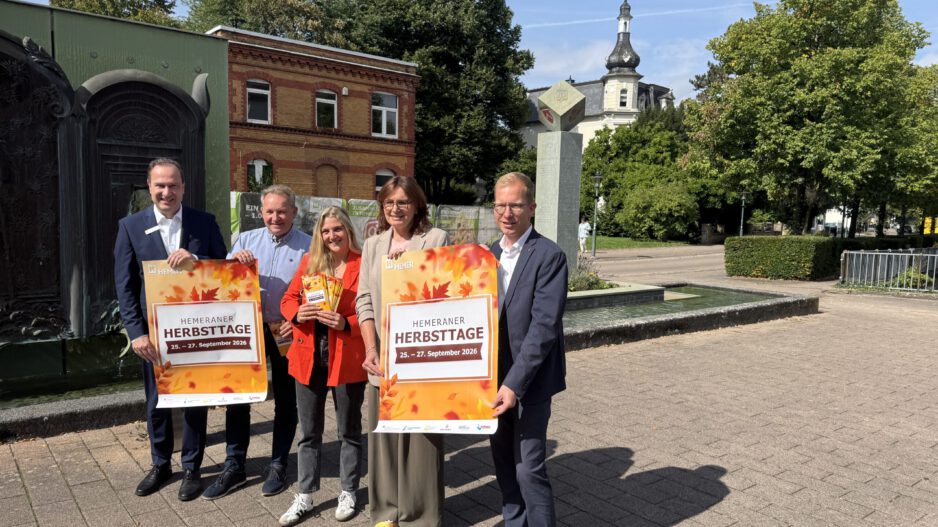 Fünf Personen präsentieren bei sonnigem Wetter vor einer Brunnenanlage in Hemer Plakate für die „Hemeraner Herbsttage“ vom 25. bis 27. September 2026.