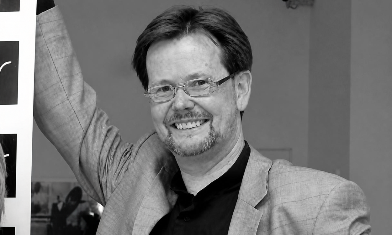 Porträtaufnahme eines lächelnden Volker Fleige in Schwarz-Weiß