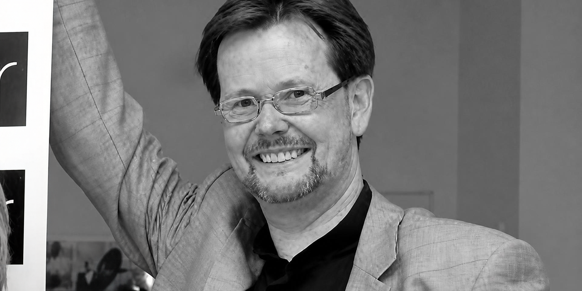 Porträtaufnahme eines lächelnden Volker Fleige in Schwarz-Weiß