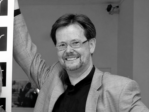 Porträtaufnahme eines lächelnden Volker Fleige in Schwarz-Weiß