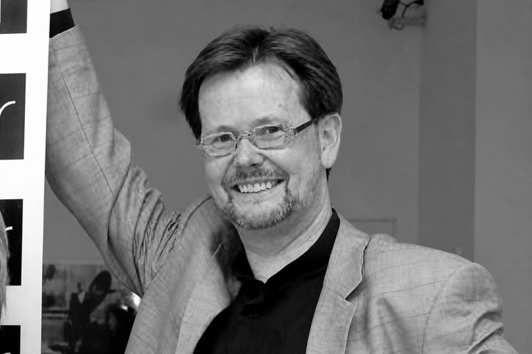 Porträtaufnahme eines lächelnden Volker Fleige in Schwarz-Weiß