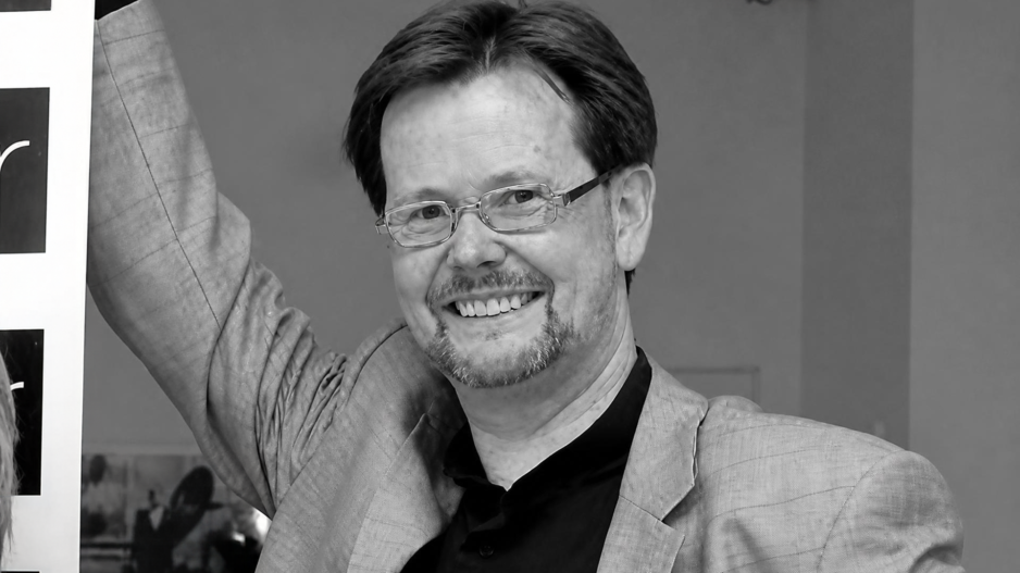 Porträtaufnahme eines lächelnden Volker Fleige in Schwarz-Weiß